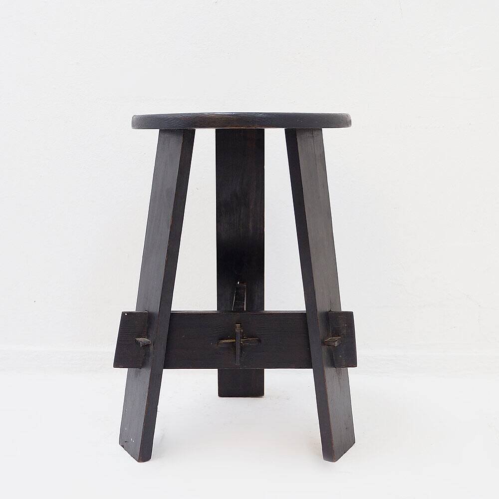Vintage black-stained wooden tripod stool with mortise joints.