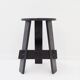 Vintage black-stained wooden tripod stool with mortise joints.