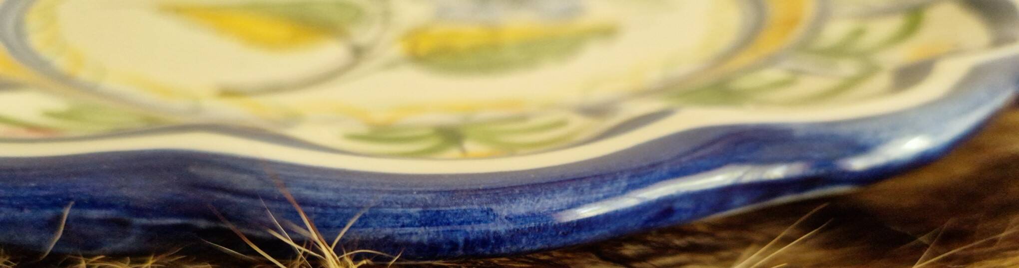 Large hand-painted French faience plate with floral decoration in folk art style.