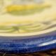 Large hand-painted French faience plate with floral decoration in folk art style.