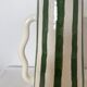 Handmade green and white striped ceramic vase with abstract corrugated handheld