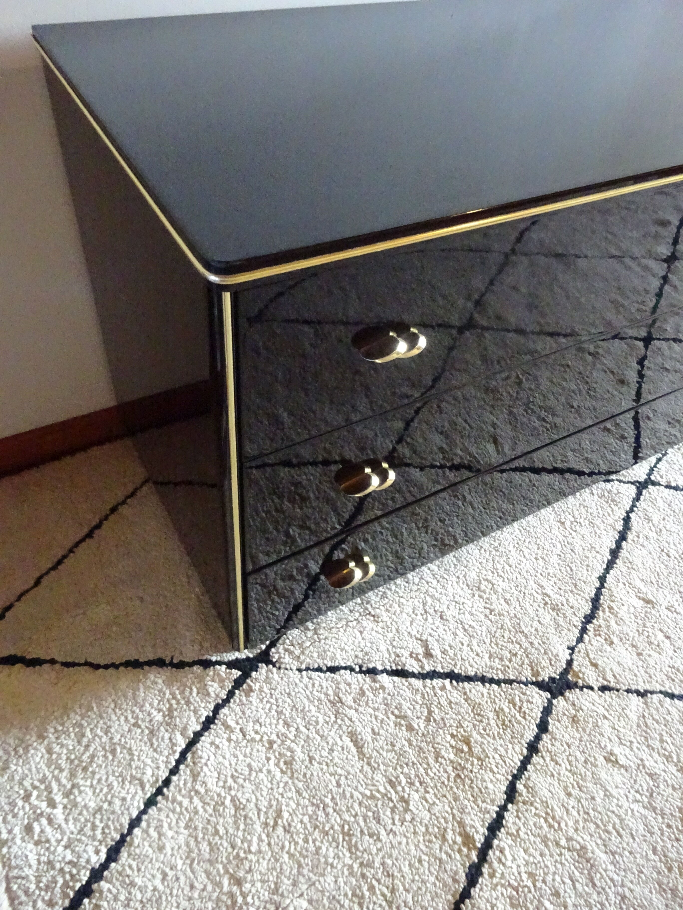 Lacquered black chest of drawers, golden brass
