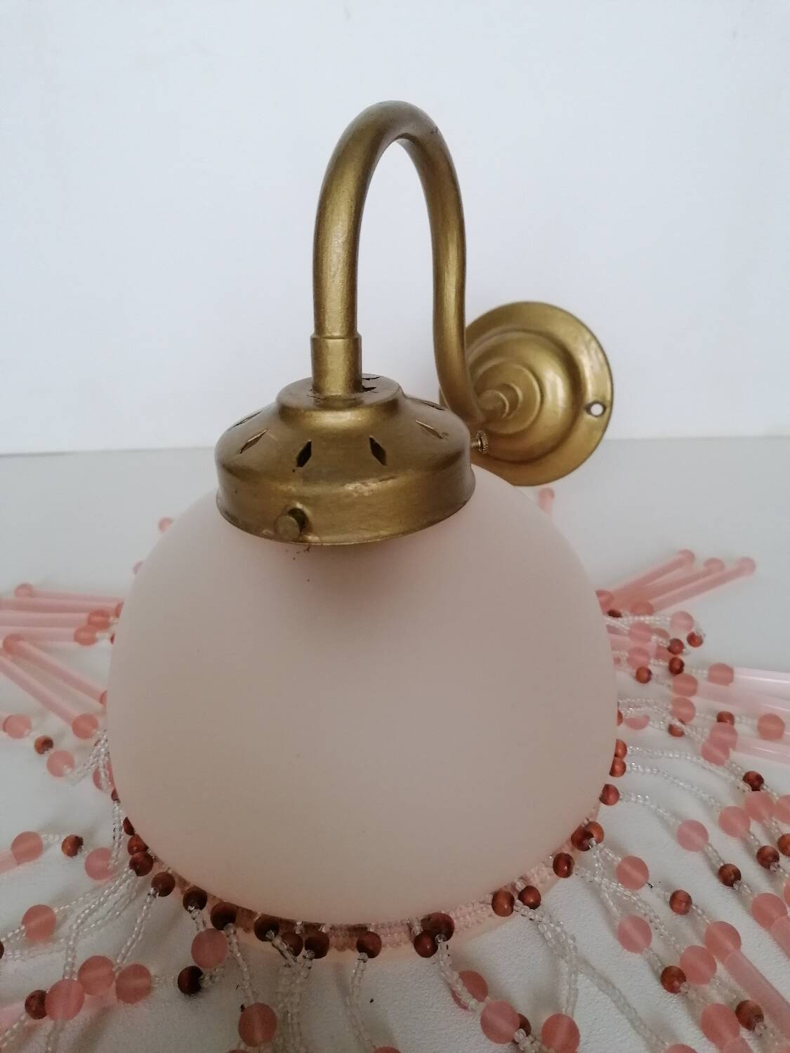 Pink glass wall lamp with garland of pearls