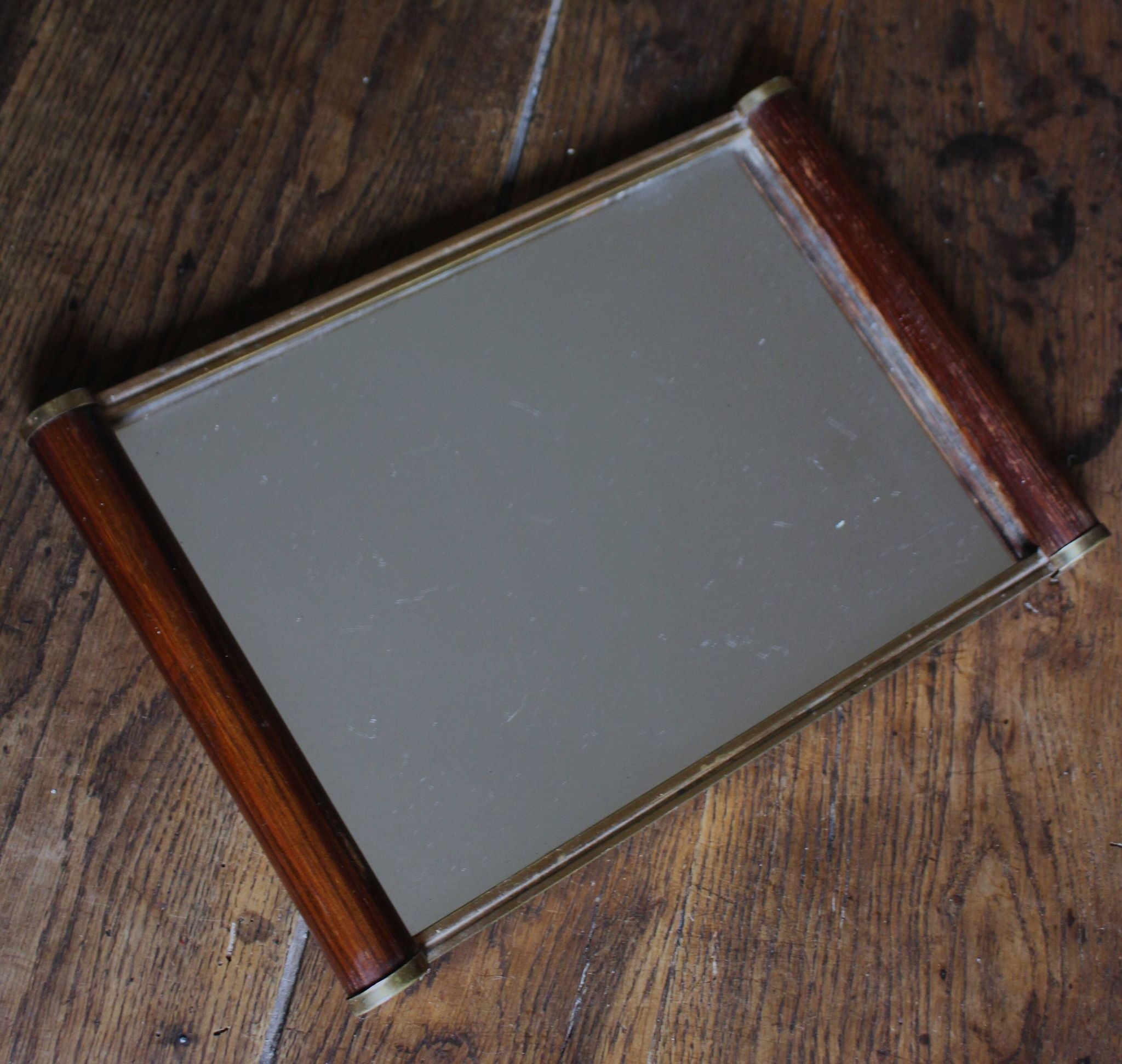 Rectangular mirror tray with wooden handles and gilding.