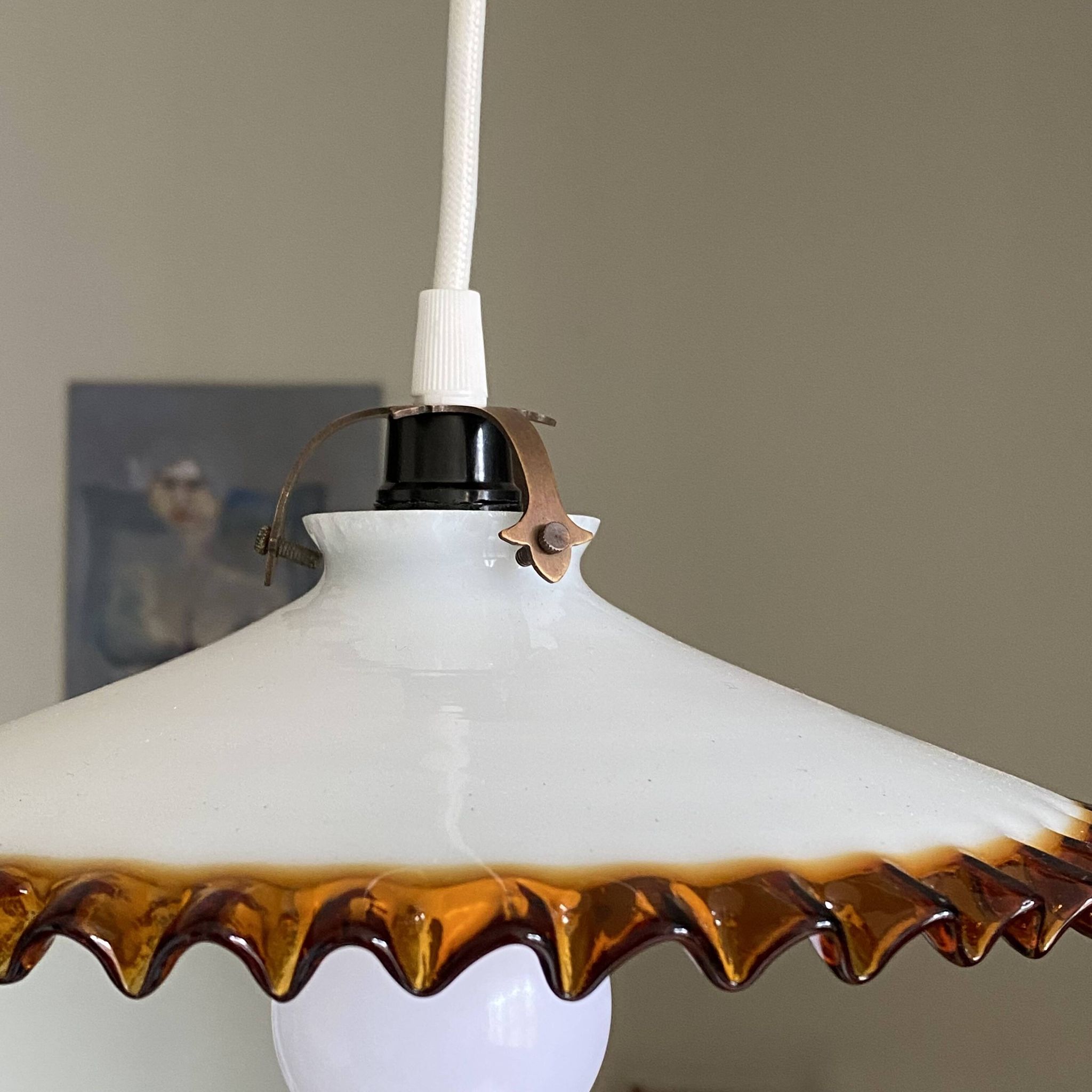 Old pendant light with a white opaline glass shade and a wavy border.