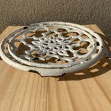 Old trivet in enameled cast iron round format white vintage tableware