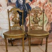 Paire de chaises de musiciens en bois sculpté et doré de style Louis XVI