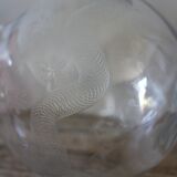 Antique glass carafe with a round belly and floral neck.