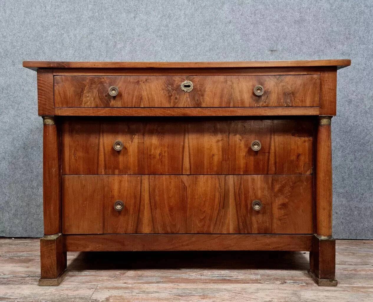 Empire period chest of drawers in walnut and gilded bronze circa 1810-1820
