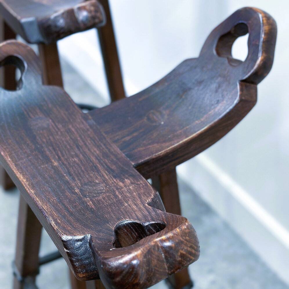 Set of 3 rustic carved oak bar stools with iron footrests, 1970s