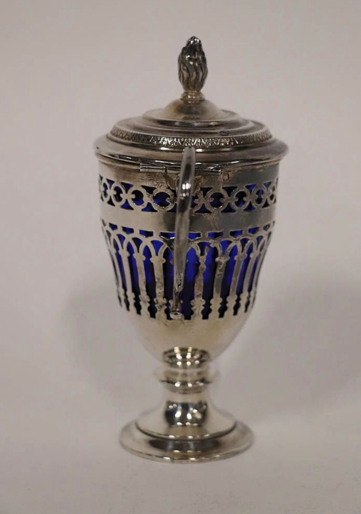 Solid silver mustard tree whose open body rests on a round pedestal.