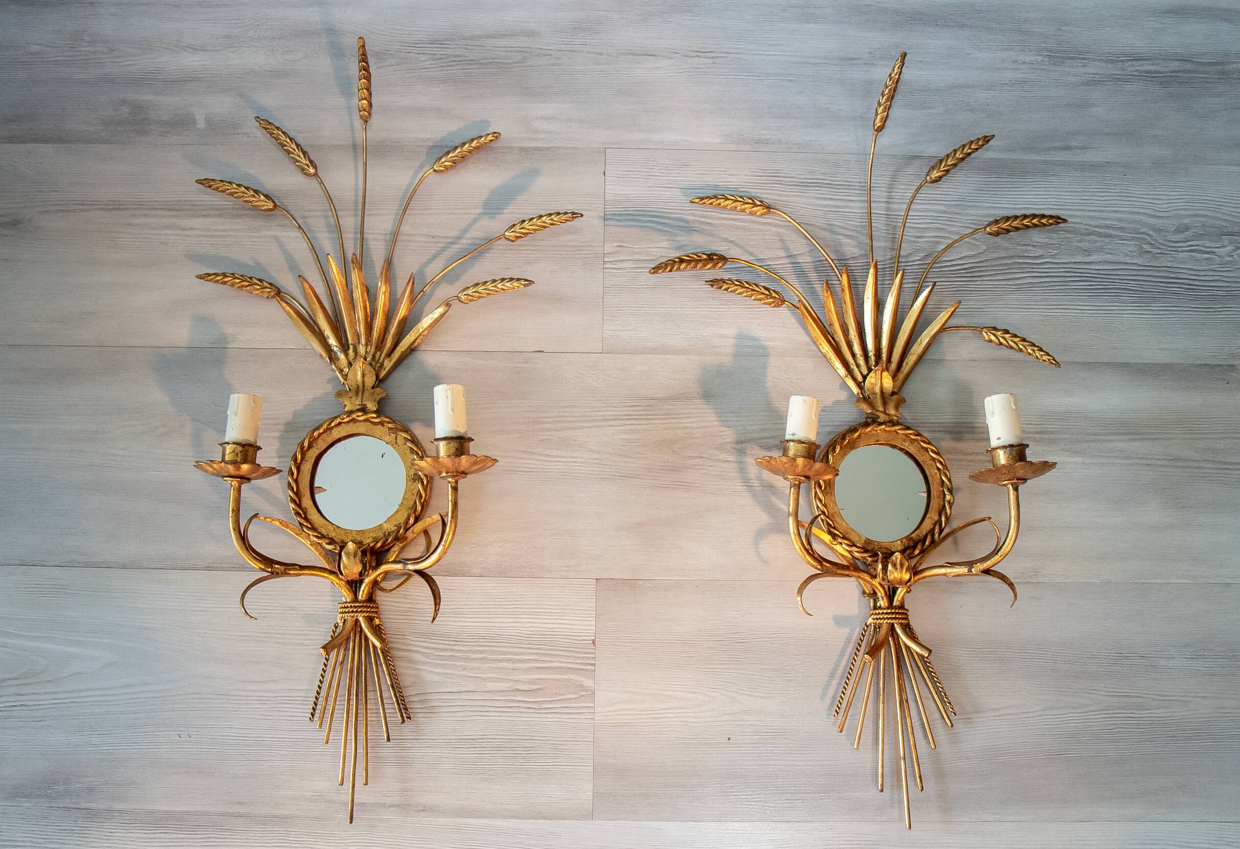 A pair of 1950s wall sconces in gold leaf metal.