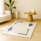 Ecru Berber rug with symbolic corner patterns.