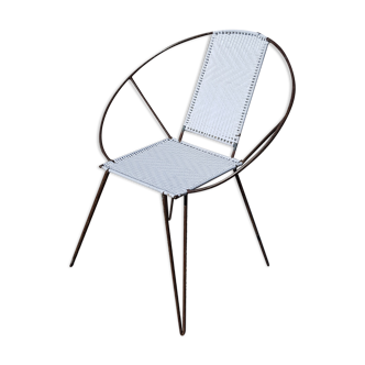 Old relax armchair in black metal and white plastic cannage