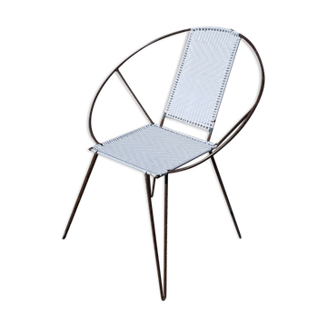 Black metal reclining armchair with white plastic caning.