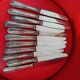 11 cheese knives in silver-filled metal and stainless steel.