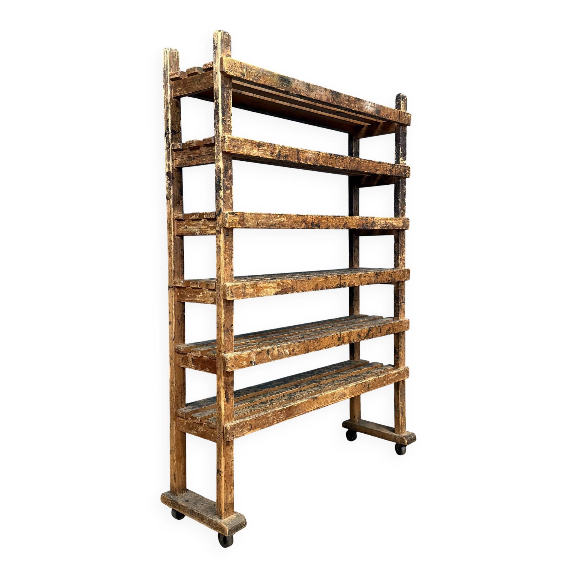 Old wooden workshop shelf with cast iron wheels.