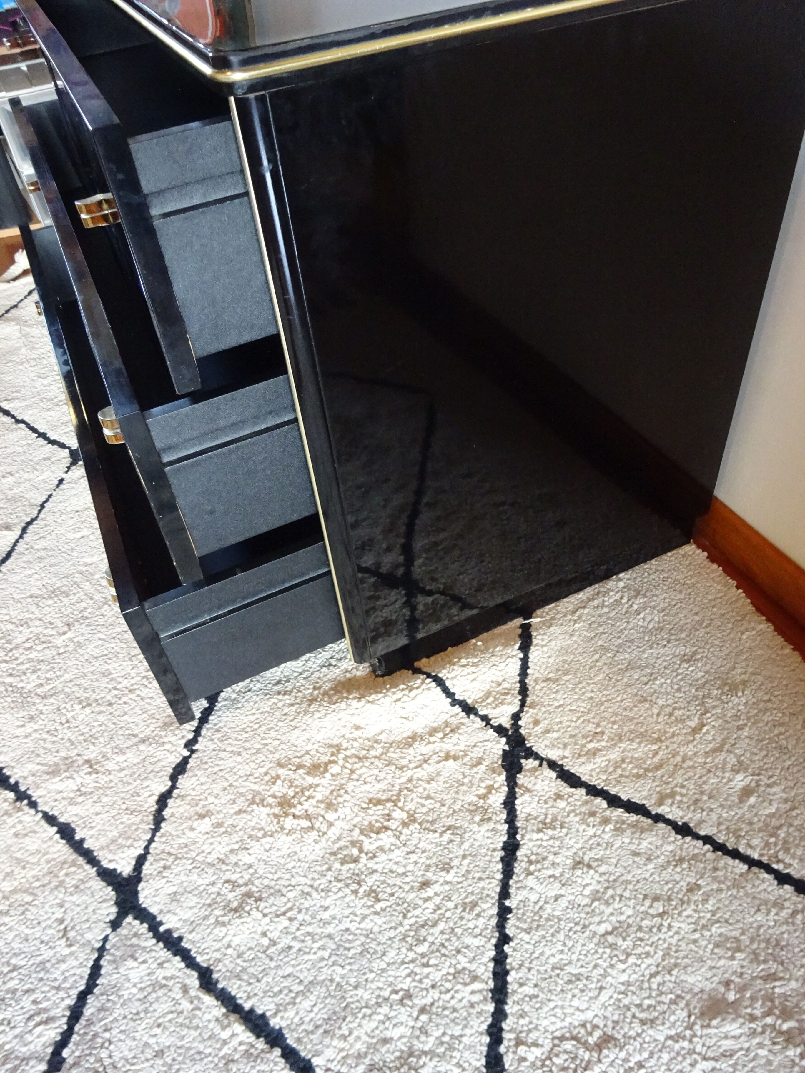 Lacquered black chest of drawers, golden brass