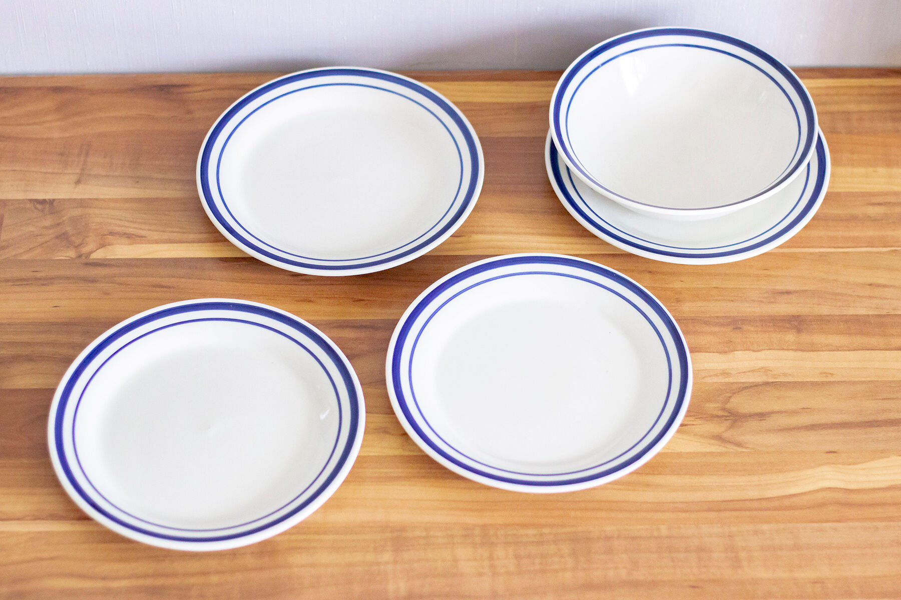 4 blue bordered dessert plates and a matching bowl
