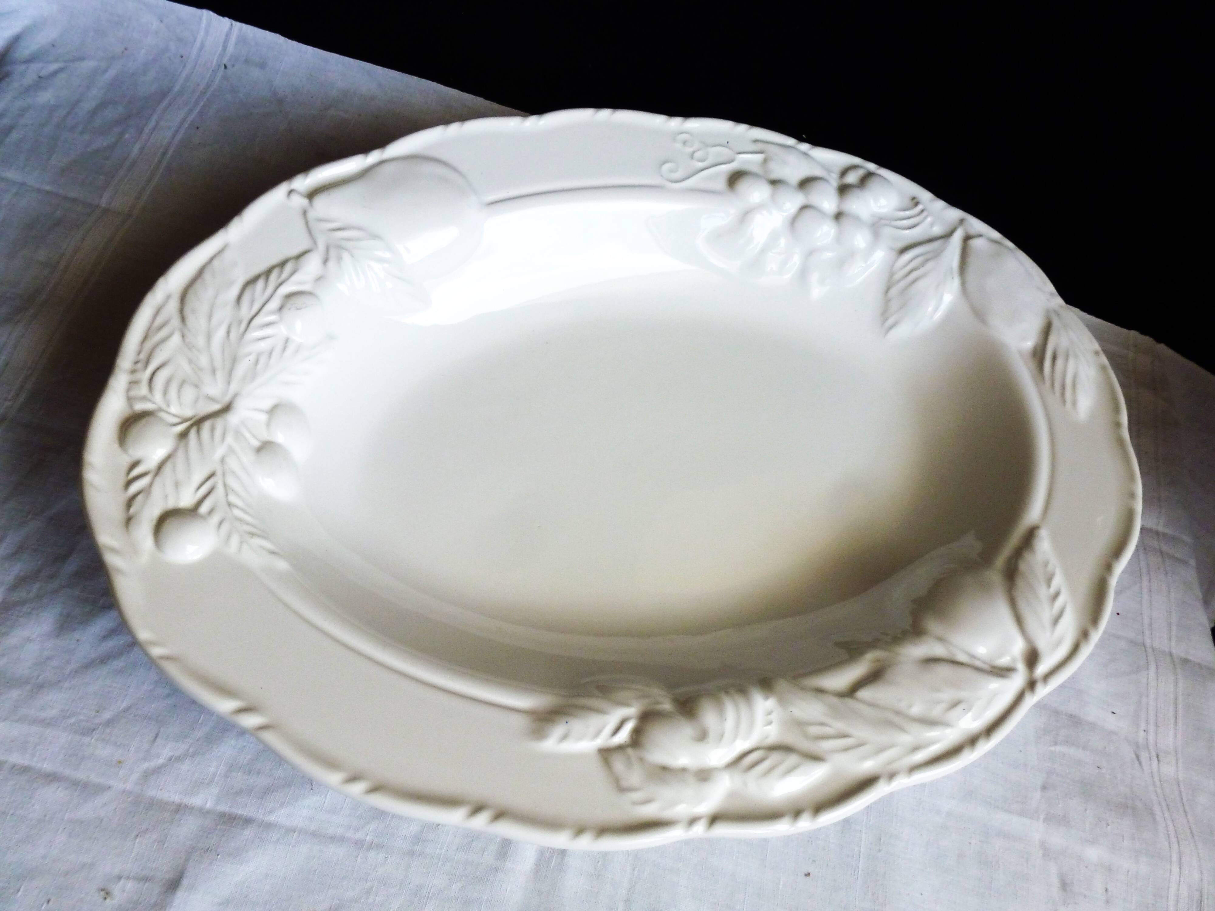 Oval white vegetable dish, an antique tableware piece in barbotine earthenware.