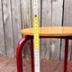 Vintage red industrial stool with a wooden seat, 1960s.