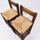 Set of 2 vintage wooden bar stools with woven straw seats.