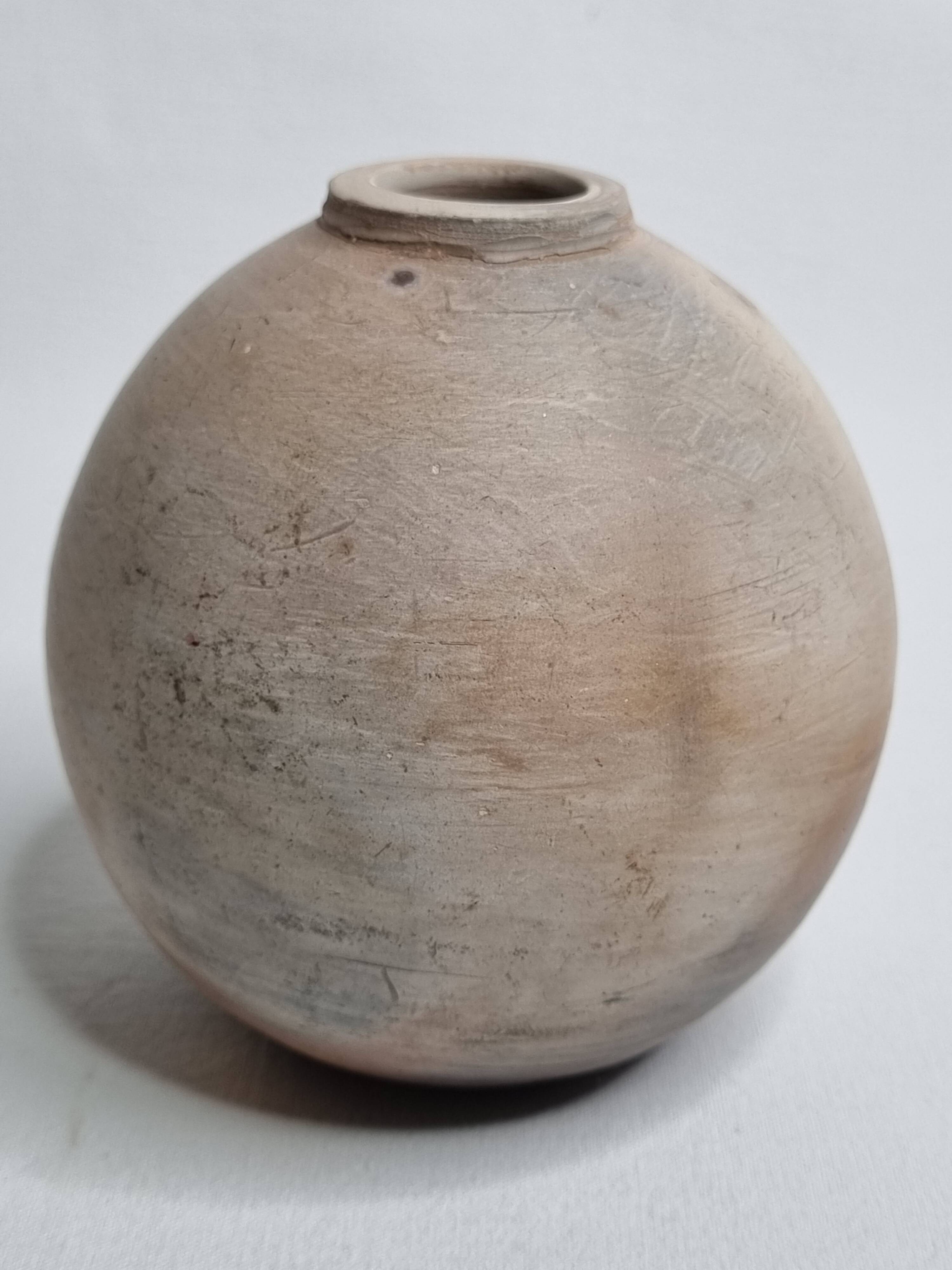 Round ceramic vase with raw finish, smoked firing, signed, late 20th century, 11 cm.