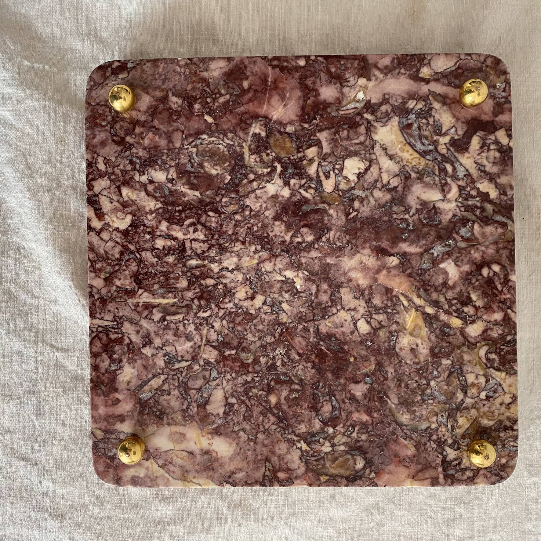 Pink marble trivet with brass ball feet.