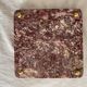 Pink marble trivet with brass ball feet.