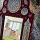 Large oriental mirror with embossed brass decoration on a red velvet background
