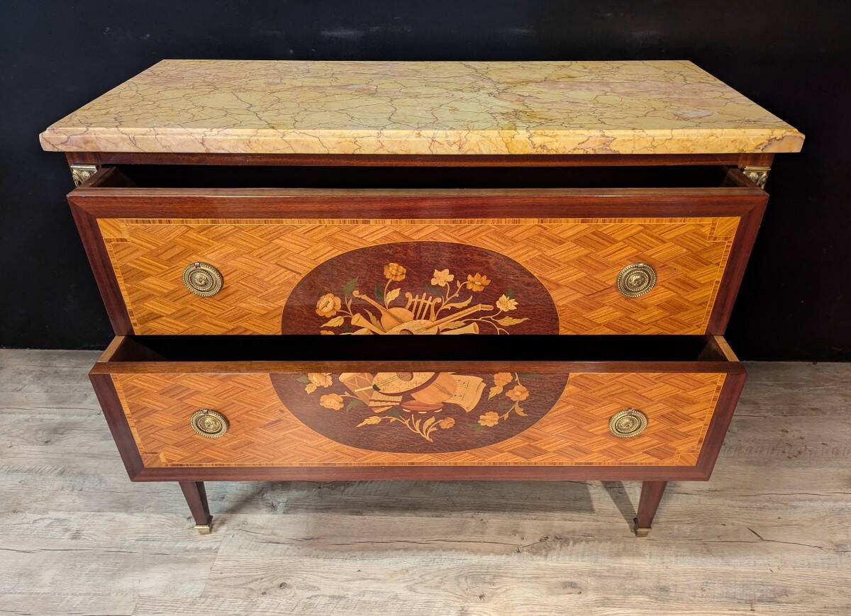 Louis XVI style commode inlaid with a decoration of instruments.