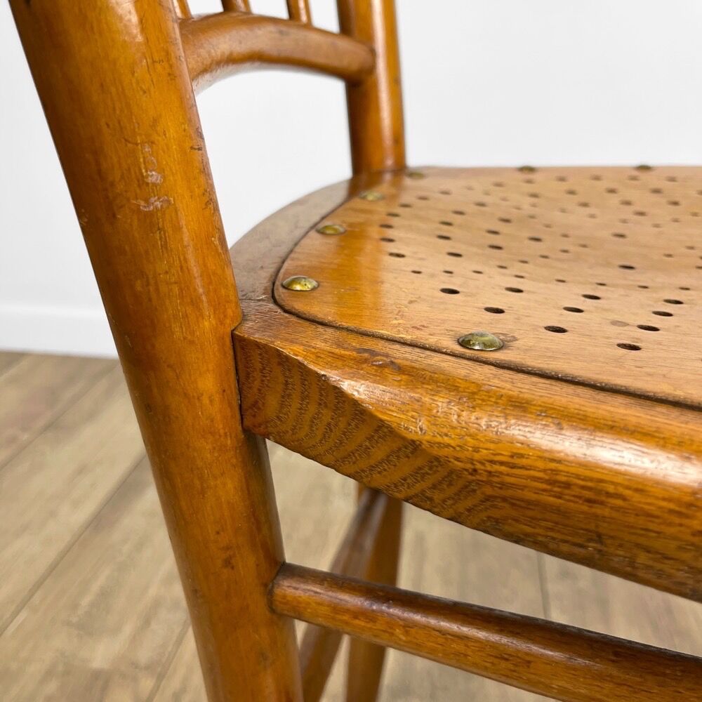 Pair of curved wood bistro chairs and studded and perforated seat