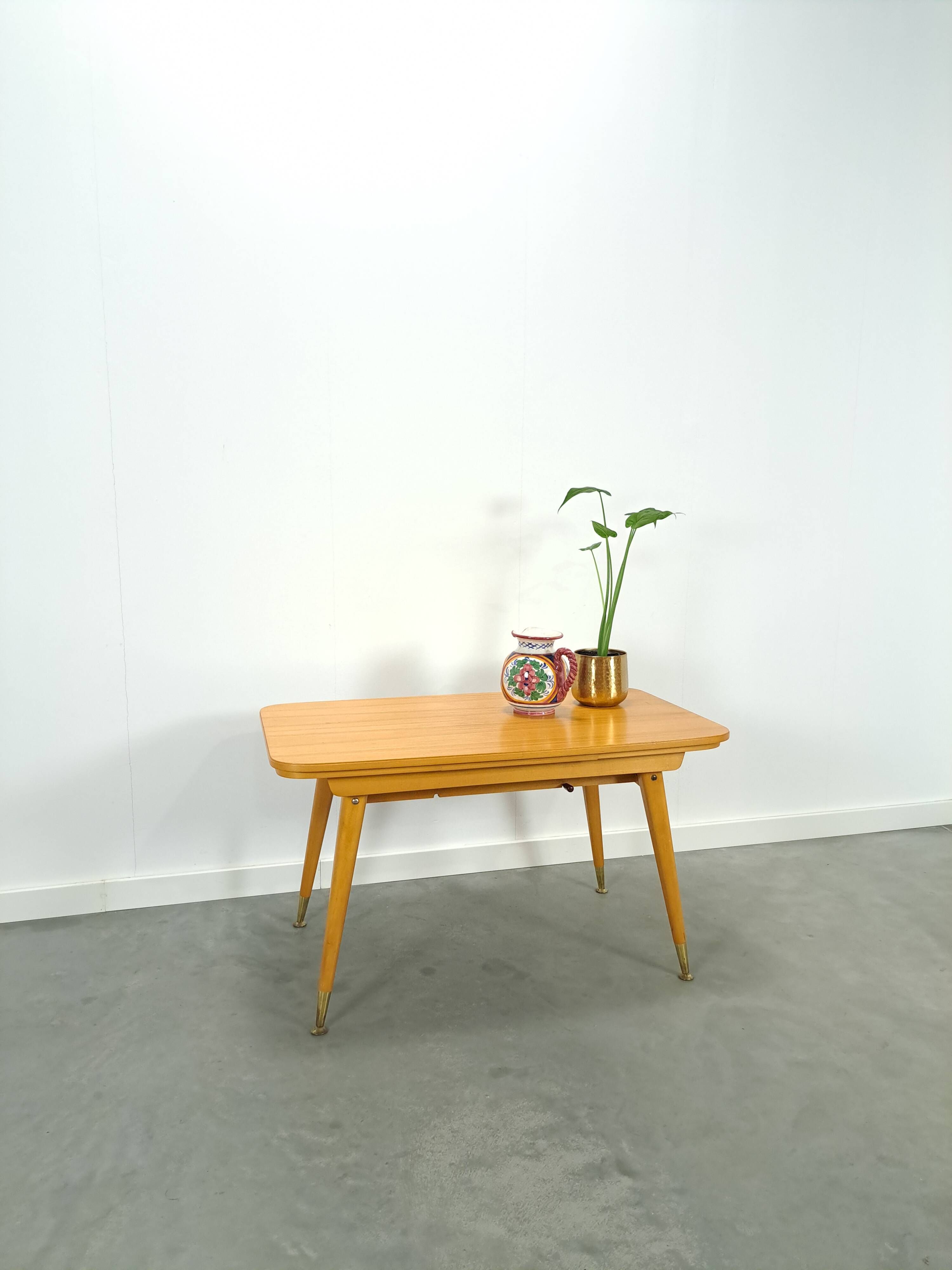 Vintage veneer table with pretty angular legs and brass at the base of the legs.