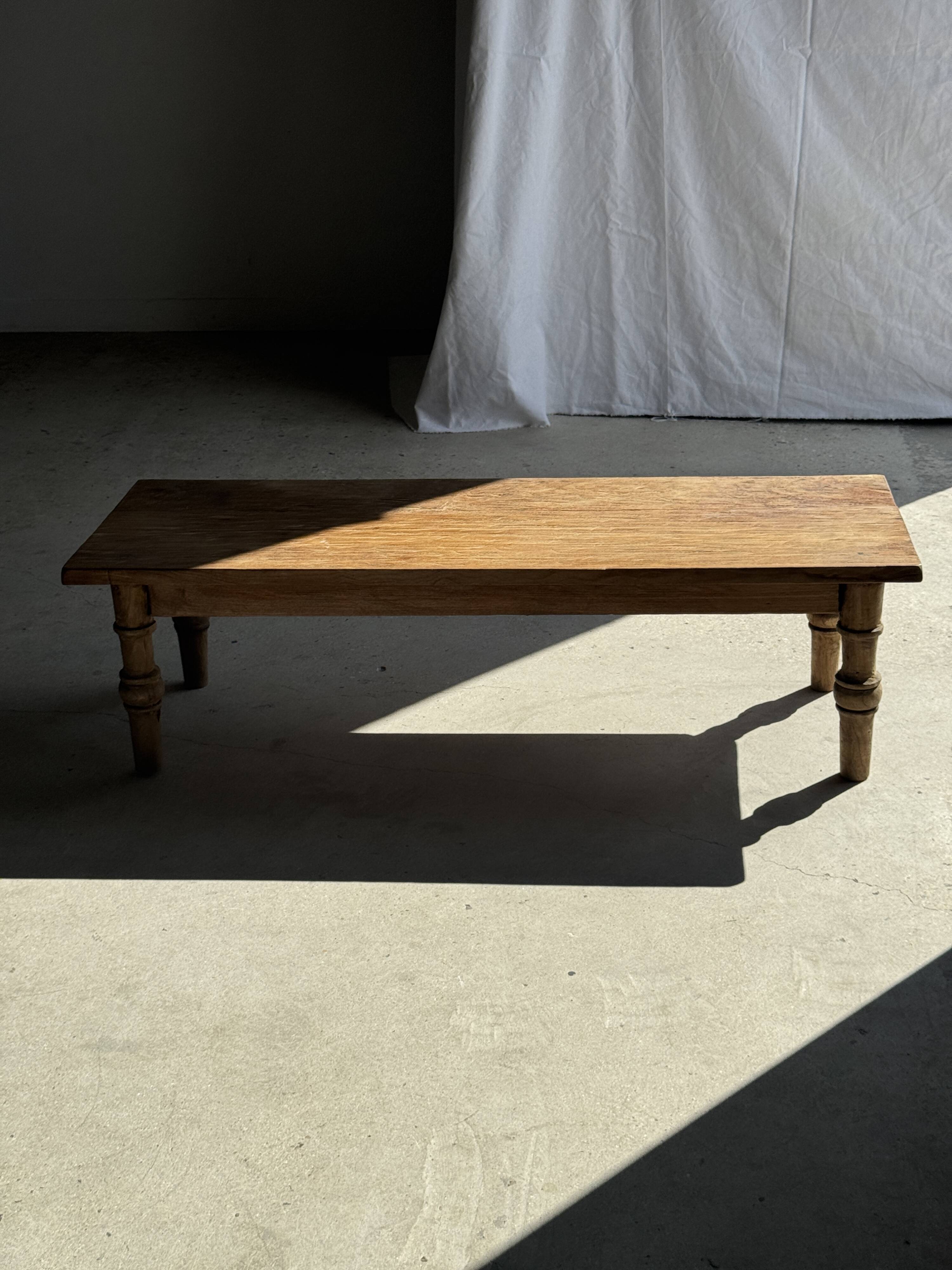 Brown Indonesian teak coffee table, with a border and cylindrical legs H40 L103.