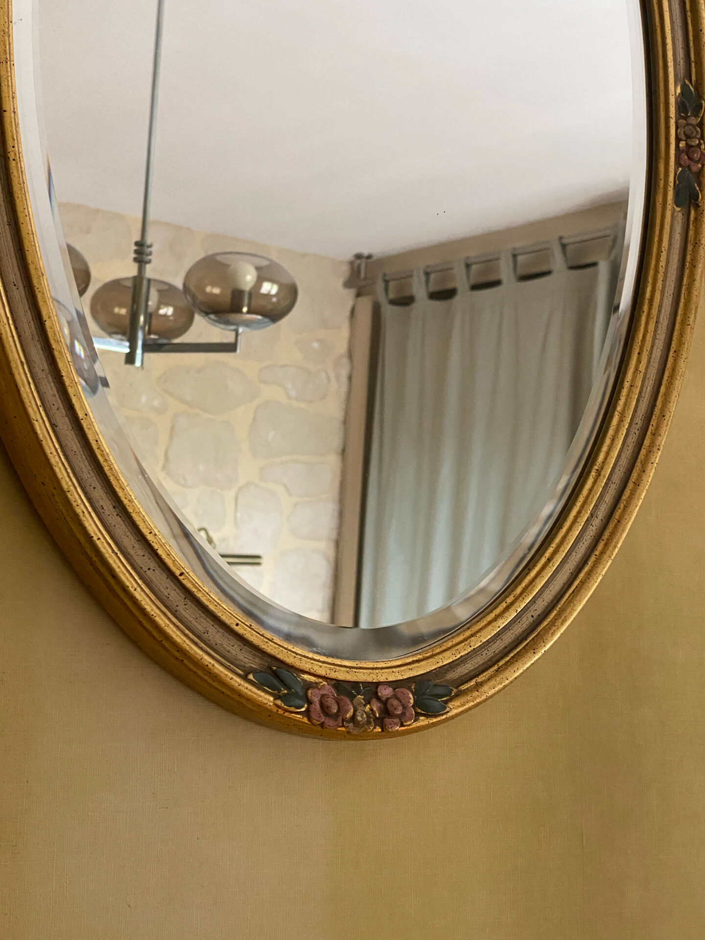 Oval wooden frame with floral decoration in gold.
