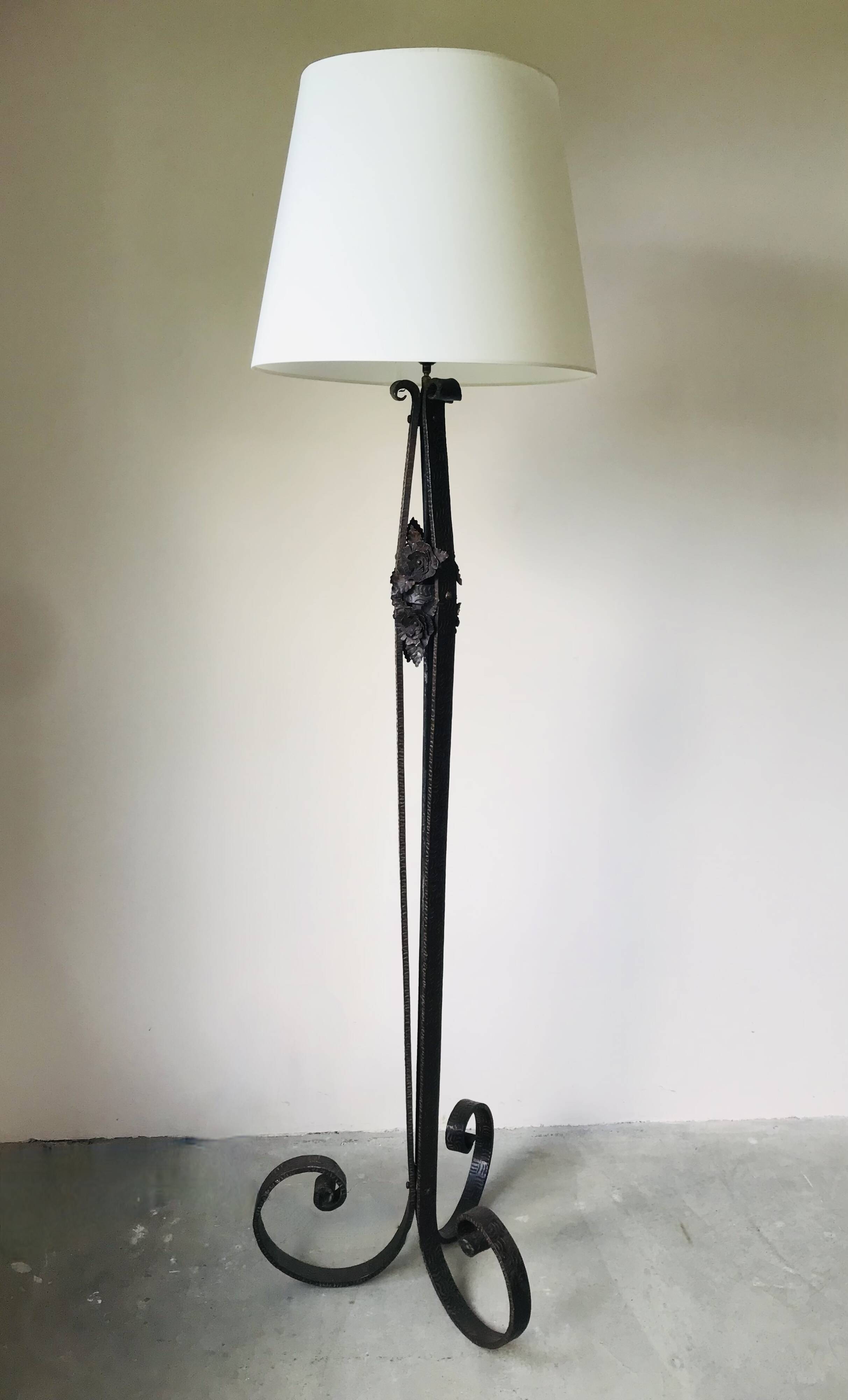 Art deco wrought iron floor lamp decorated with flowers, circa 1930.