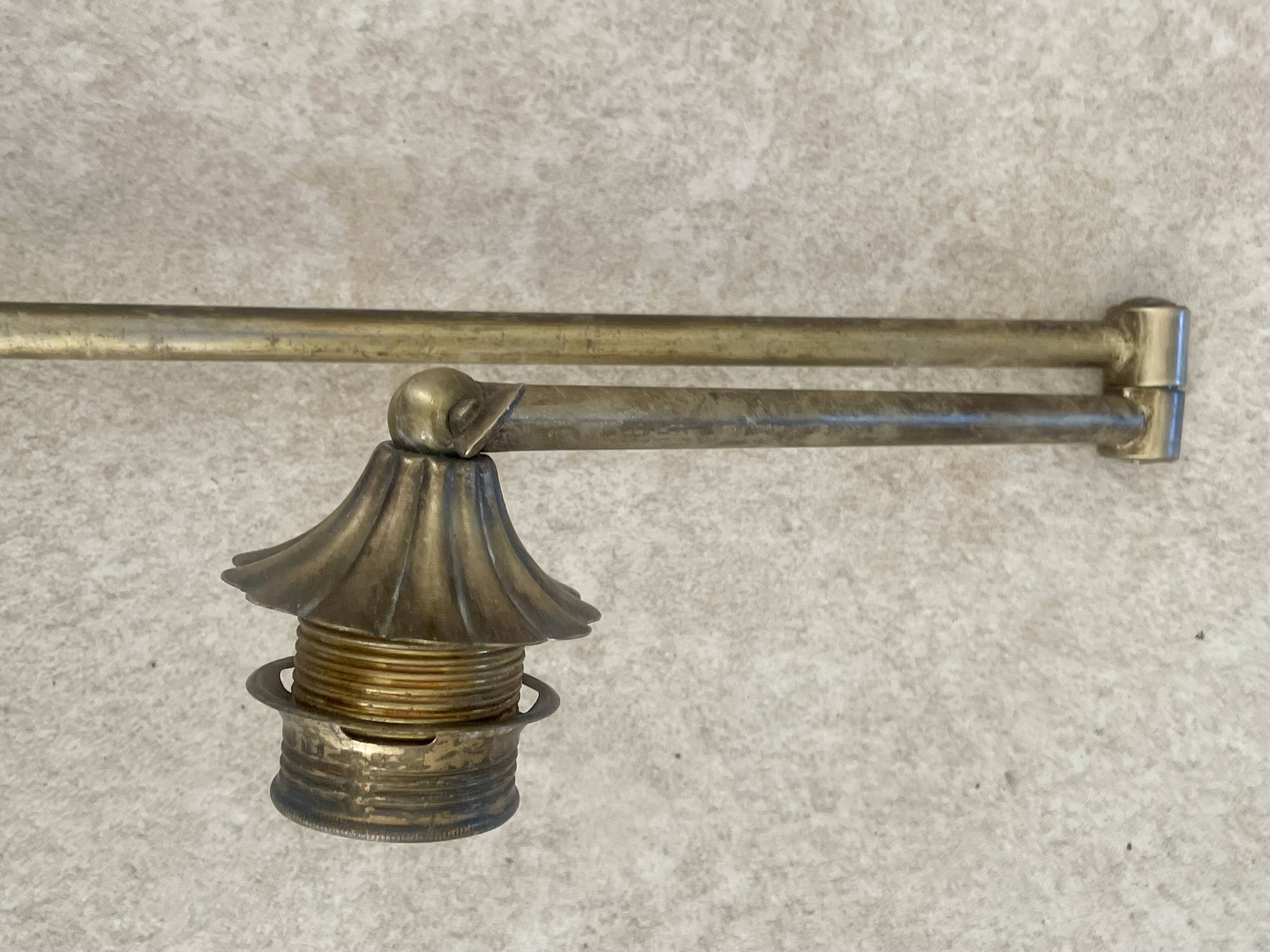 Adjustable wall light in brass and gold metal.