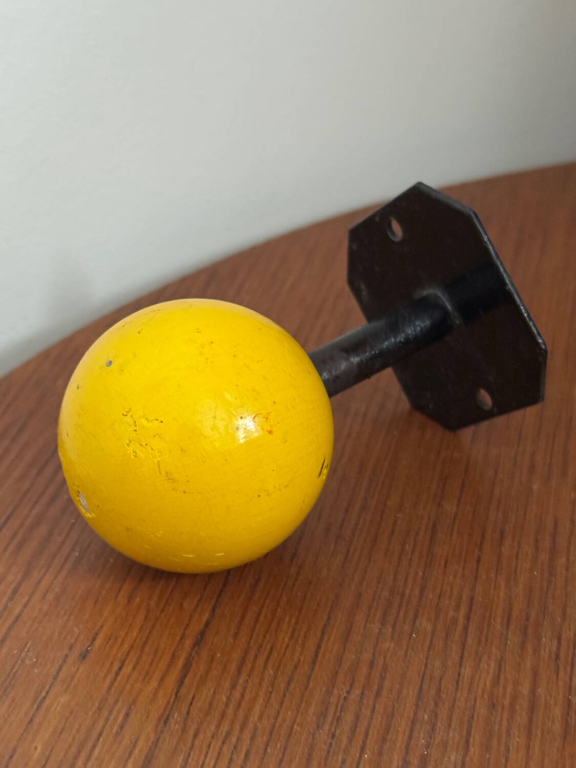 Vintage yellow wooden wall-mounted ball coat hook.