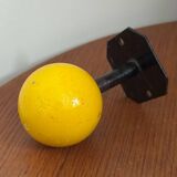 Vintage yellow wooden wall-mounted ball coat hook.