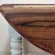 Round walnut table convertible into a console.