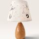 Wood-turned lamp with a hand-drawn lampshade, circus patterns.