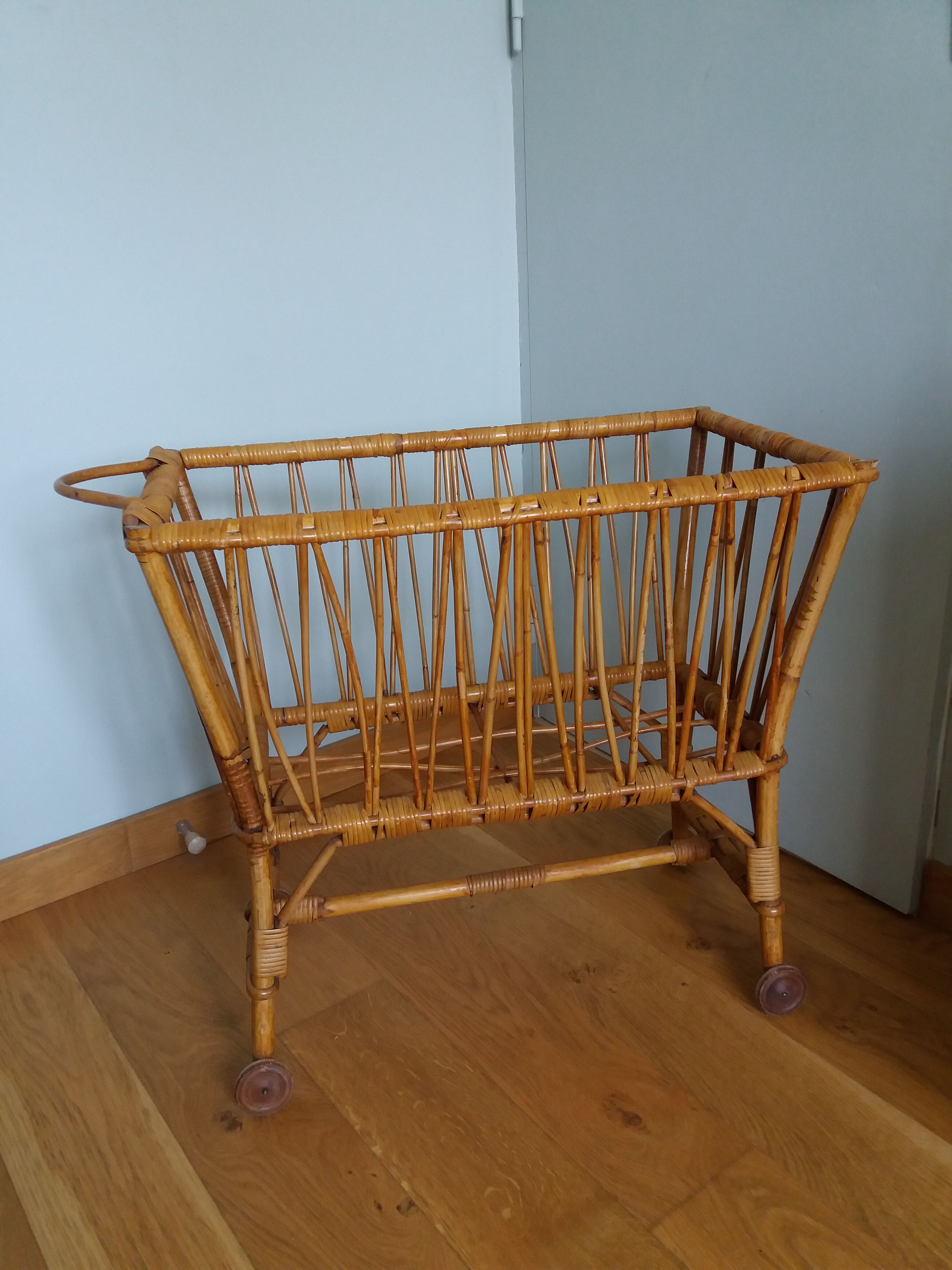 Rattan wicker cradle on wooden wheels