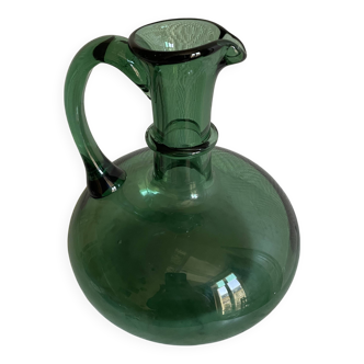 Green glass carafe with a curved shape
