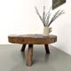 Brutalist coffee table in solid teak, monolithic slab, tripod base.
