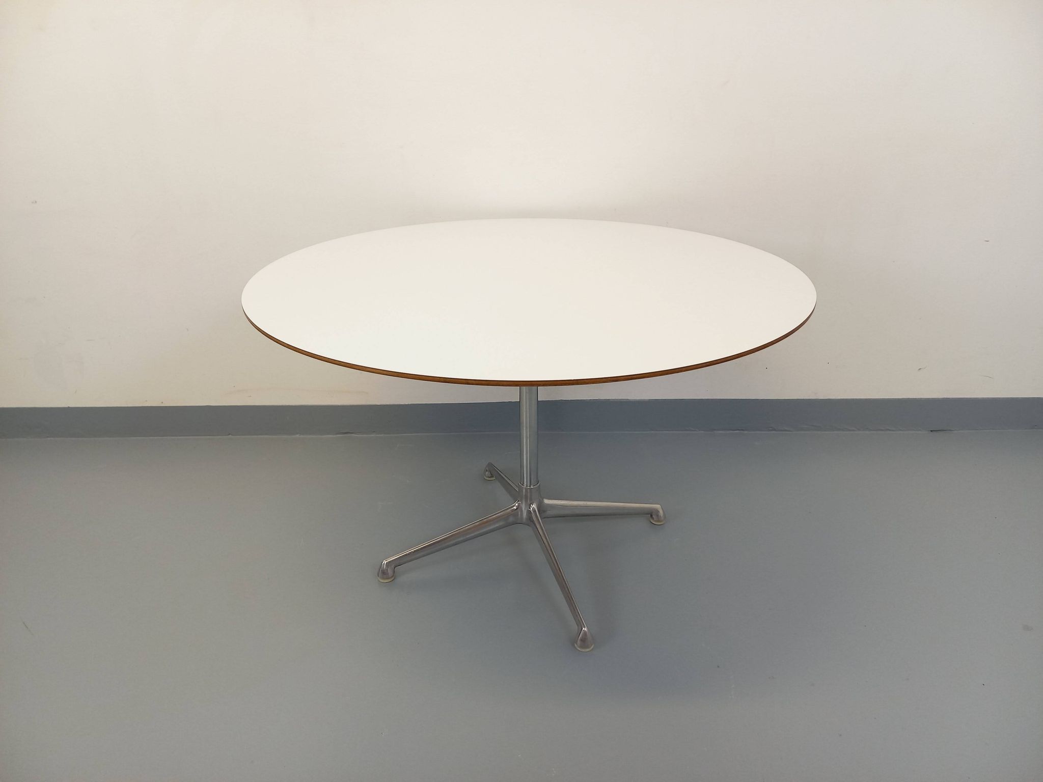 Vintage Eames round table for Vitra in white melamine, wood, and metal.