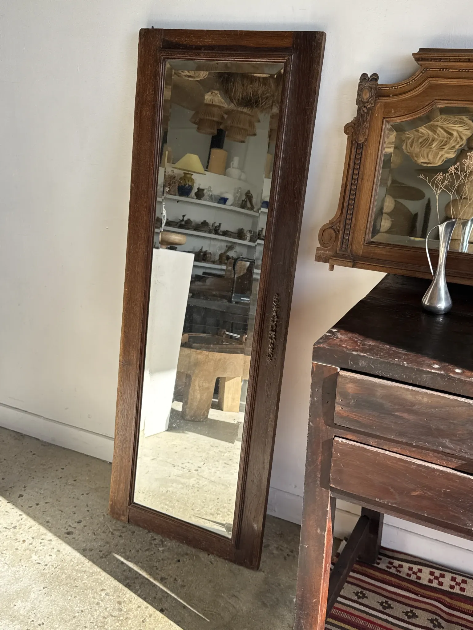 Antique mirror door (left) of a brown oak wardrobe with bevelled glass.