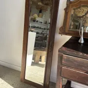 Antique mirror door (left) of a brown oak wardrobe with bevelled glass.