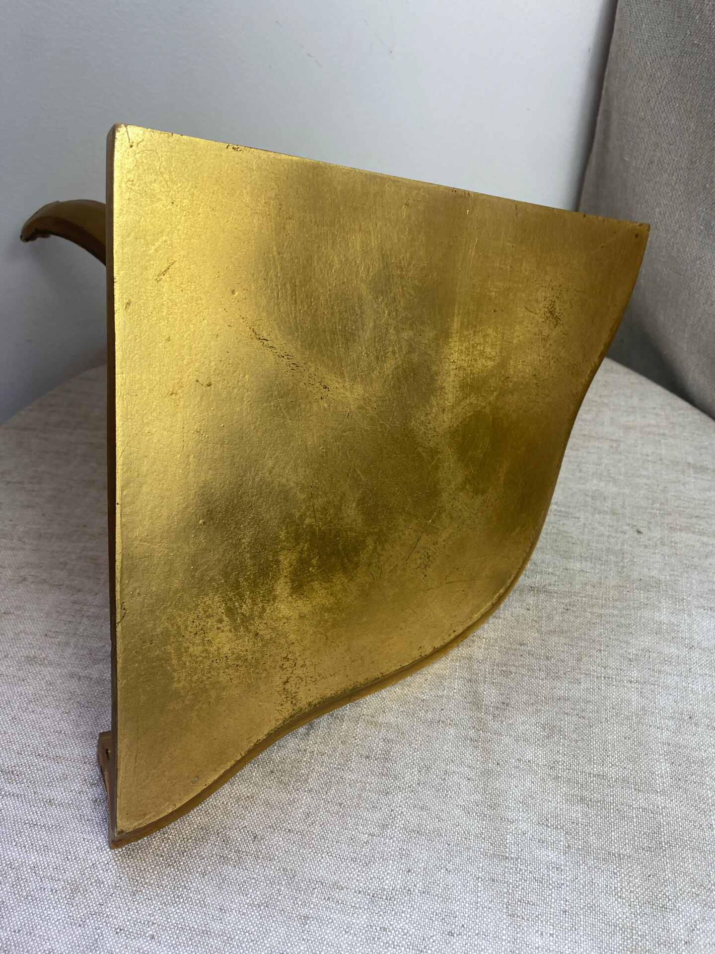 Small corner console in resin with a gold finish.