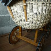 Old wooden cradle and wicker on wheels
