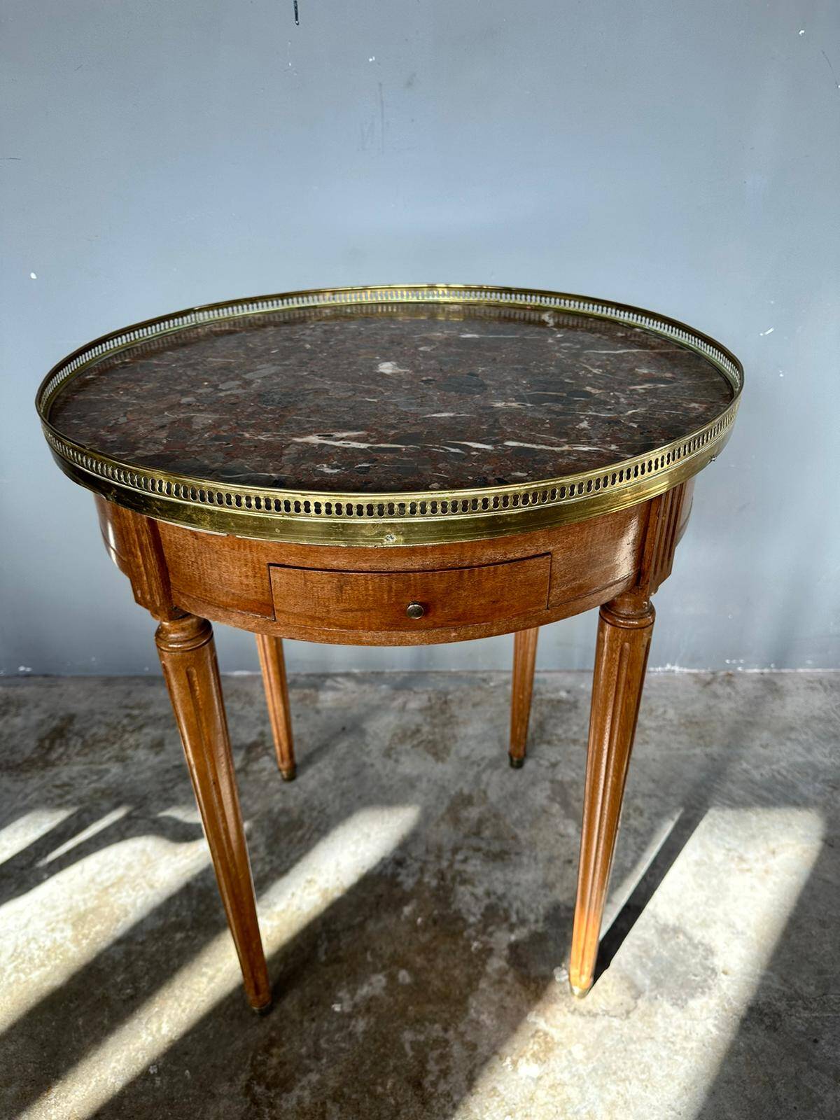 Hot water bottle table with a marble top and a brass gallery.